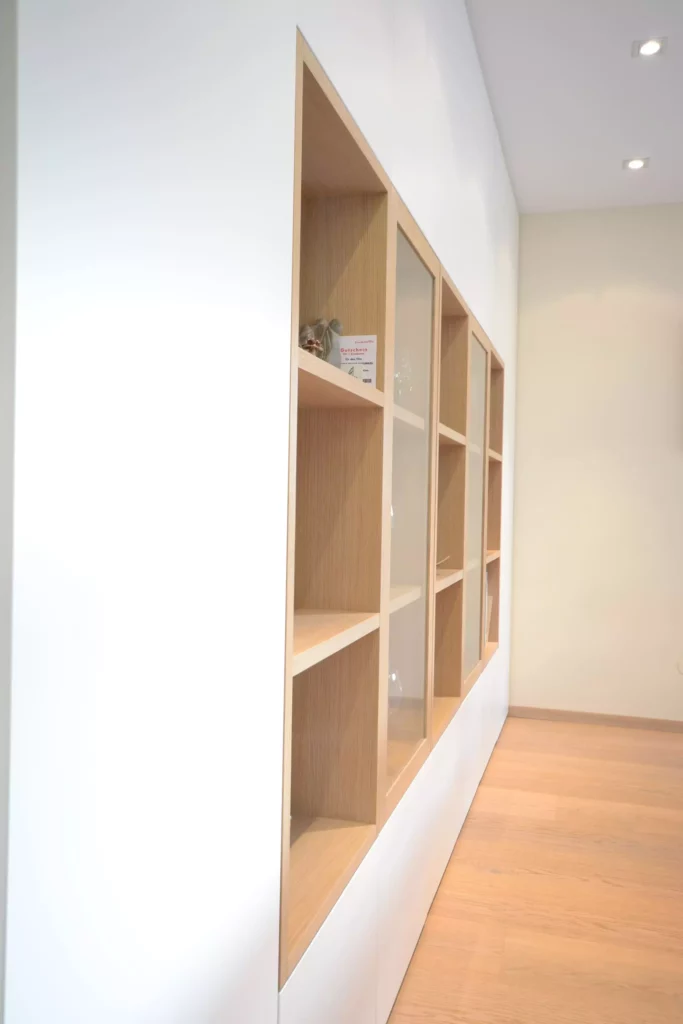 Maßgefertigte Poliform Vitrine mit Holzrahmen und Glasfront in modernem Innenraum mit hellem Holzboden, Referenzen