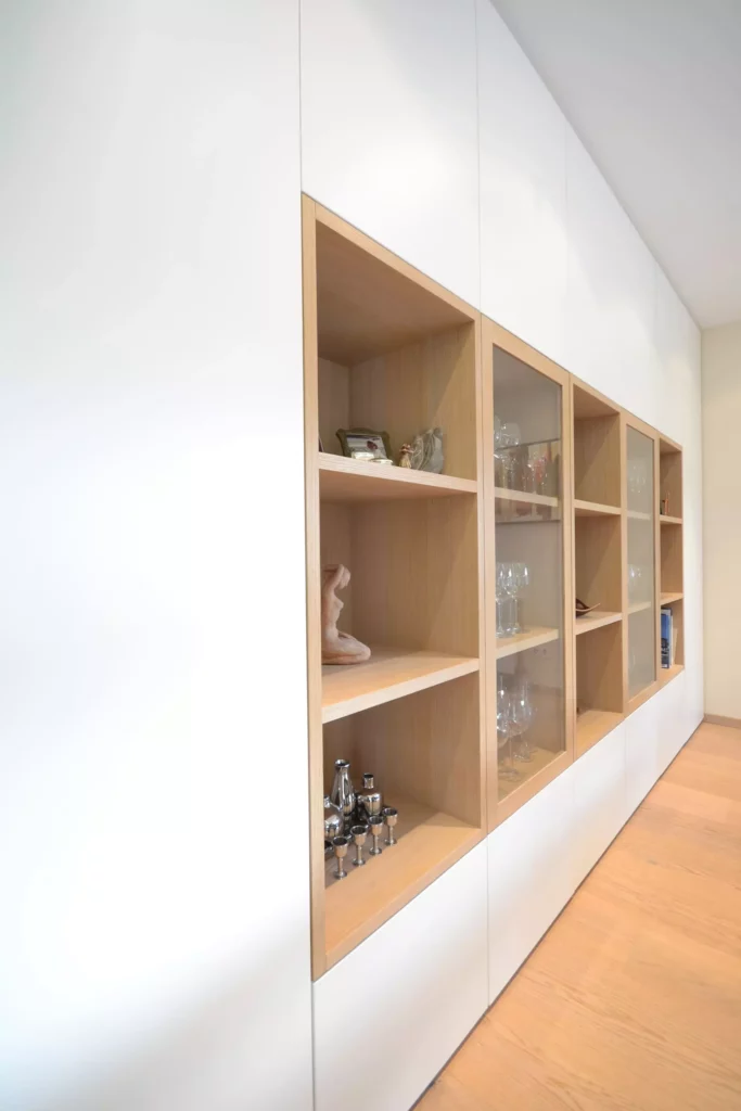 Maßgefertigte Poliform Wohnwand mit weißen Fronten und offenen Eichenholzregalen, teils mit Glastüren, dekoriert, Referenzen