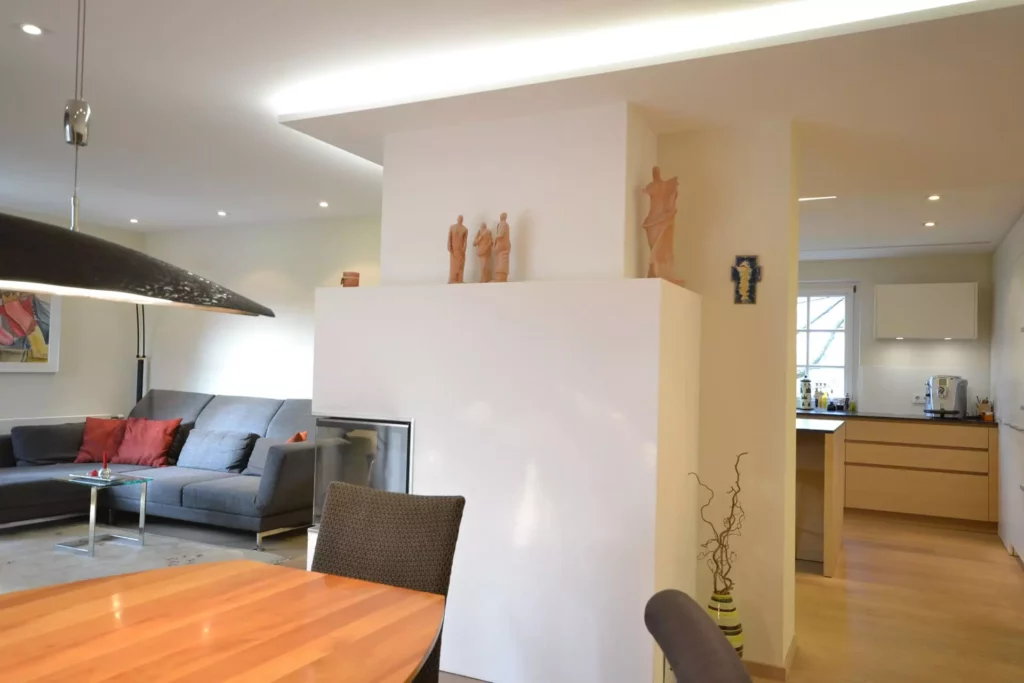 Moderner Wohnraum mit Poliform Sofa, Kamin, Holz-Esstisch und offener Küche in hellem Design und maßgefertigter, Referenzen