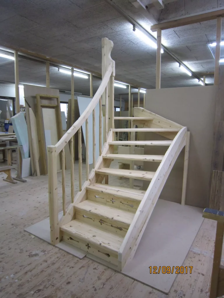 Unbehandelte Holztreppe mit geschwungenem Geländer in einer Tischlerei-Werkstatt als Maßanfertigung für, Referenzen