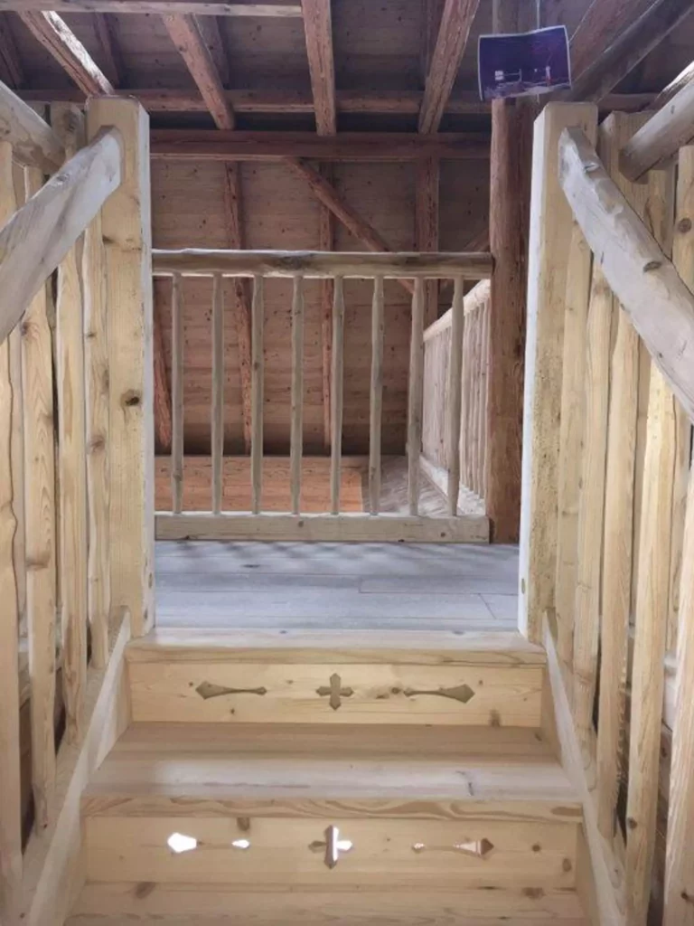 Holztreppe mit geschnitzten Verzierungen und rustikalem Geländer aus naturbelassenem Holz in einer, Referenzen