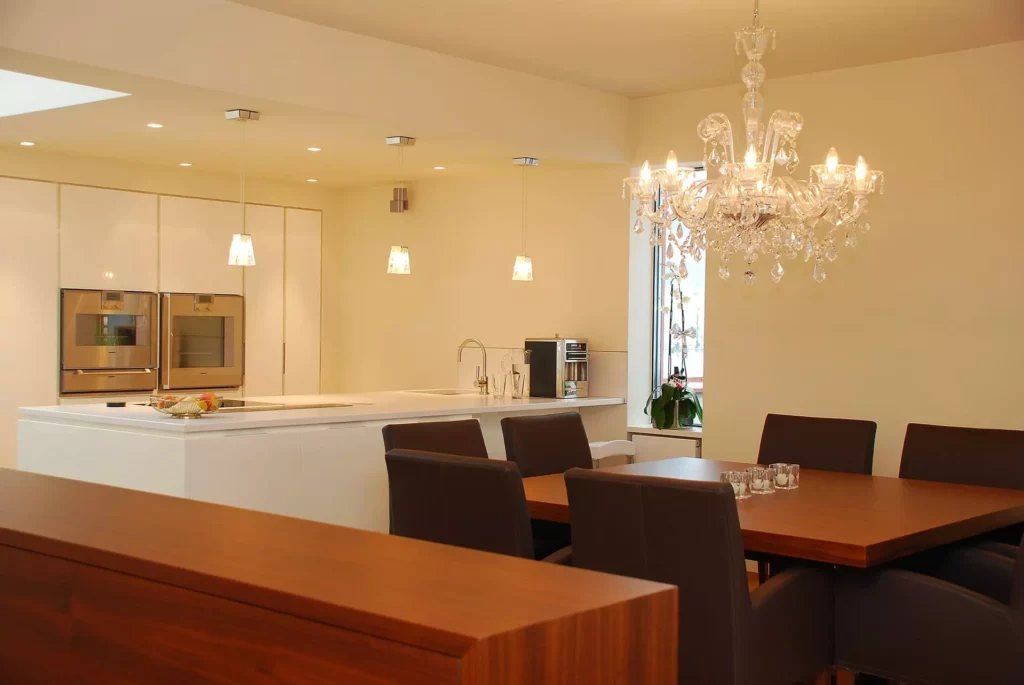 Moderner Wohnraum mit maßgefertigter Holzmöbel-Essgruppe, weißer Küche mit Einbaugeräten und, Referenzen