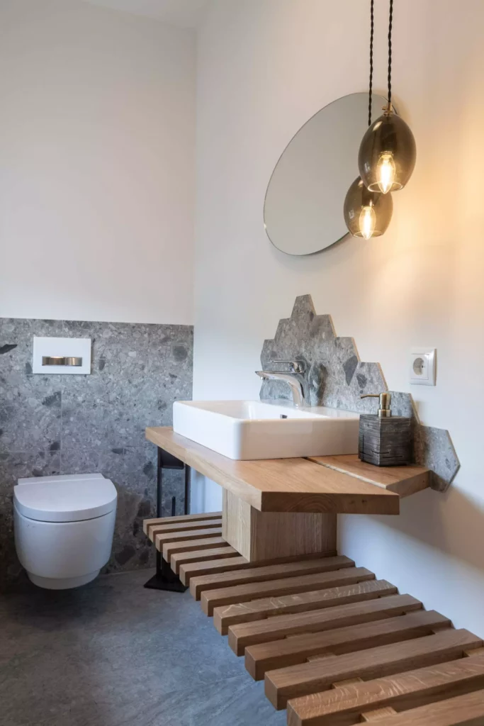 Modernes Badezimmer mit hängendem WC, Holz-Waschtisch mit weißem Aufsatzbecken, sechseckigen grauen Fliesen und, Minotti