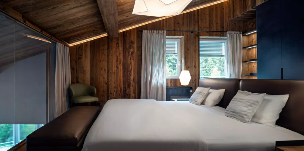 Schlafzimmer mit maßgefertigtem Massivholzbett, Lederbettkopfteil, Holzverkleidung, indirekter Beleuchtung und, Minotti