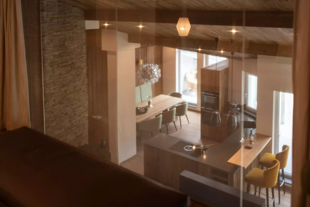 Moderner Wohnraum mit Massivholzküche, Essbereich mit grünen Stühlen und gelben Barhockern, Innenarchitektur von M, Minotti