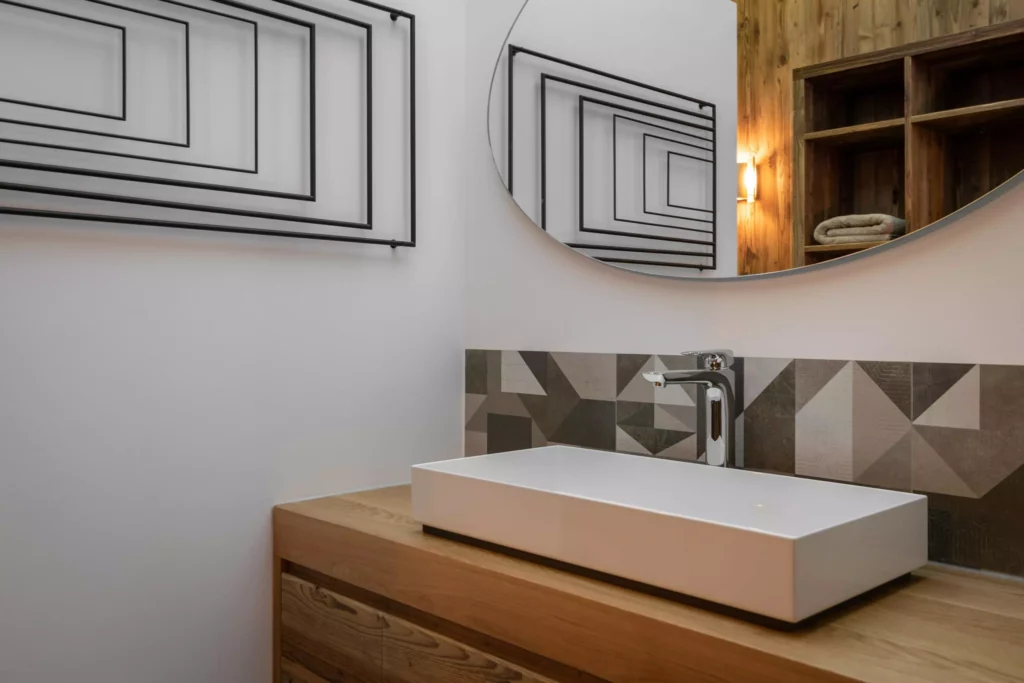 Moderner Badezimmer-Waschtisch mit rechteckigem weißen Becken, Holzunterschrank, geometrischen Fliesen und rundem, Minotti