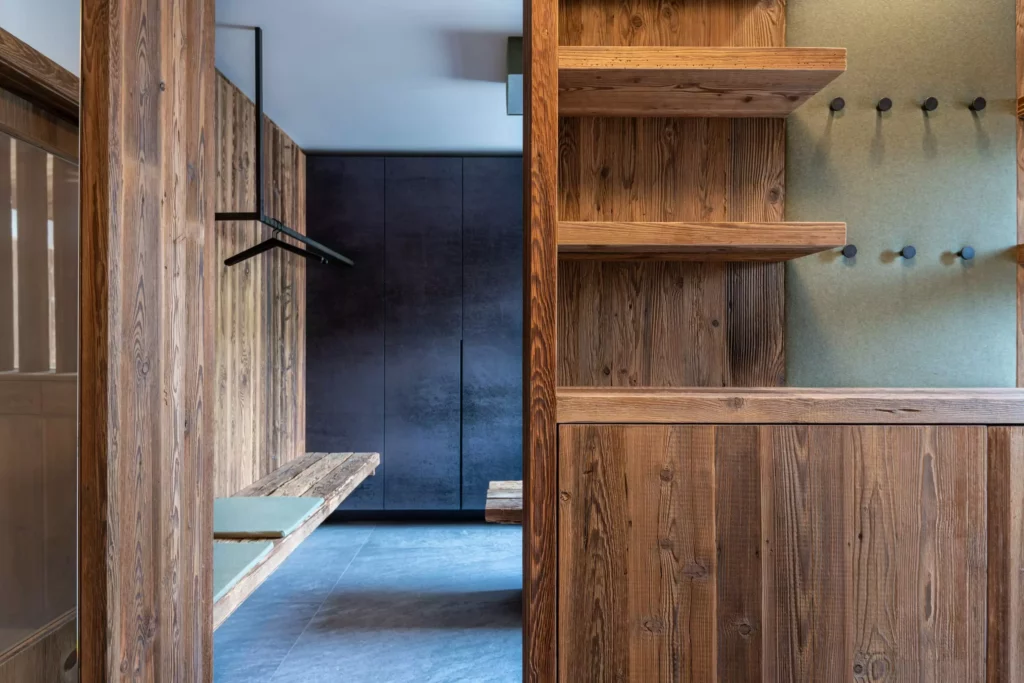 Eingangsbereich mit maßgefertigten Massivholzmöbeln, Sitzbank, Garderobenhaken und dunklem Schrank, Minotti