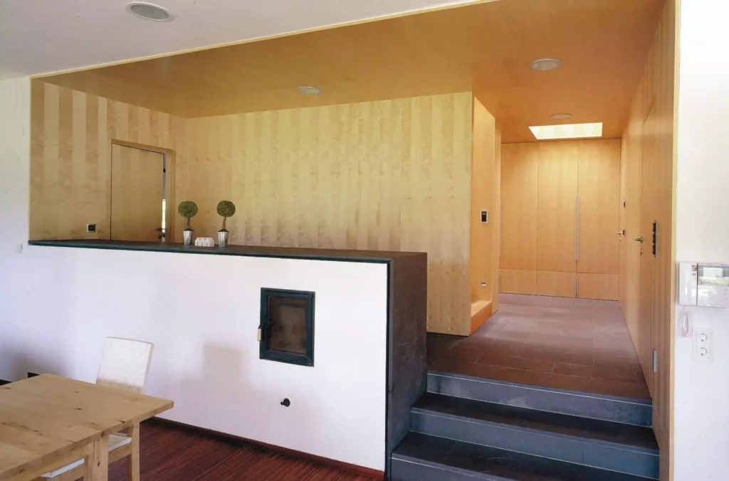 Moderner Wohnraum mit maßgefertigten Holzvertäfelungen, integriertem Kamin, Treppe und minimalistischer, Referenz