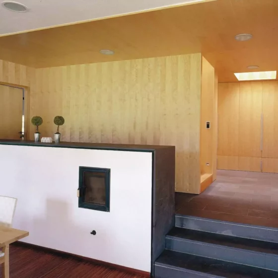 Moderner Wohnraum mit maßgefertigten Holzvertäfelungen, integriertem Kamin, Treppe und minimalistischer, Referenz