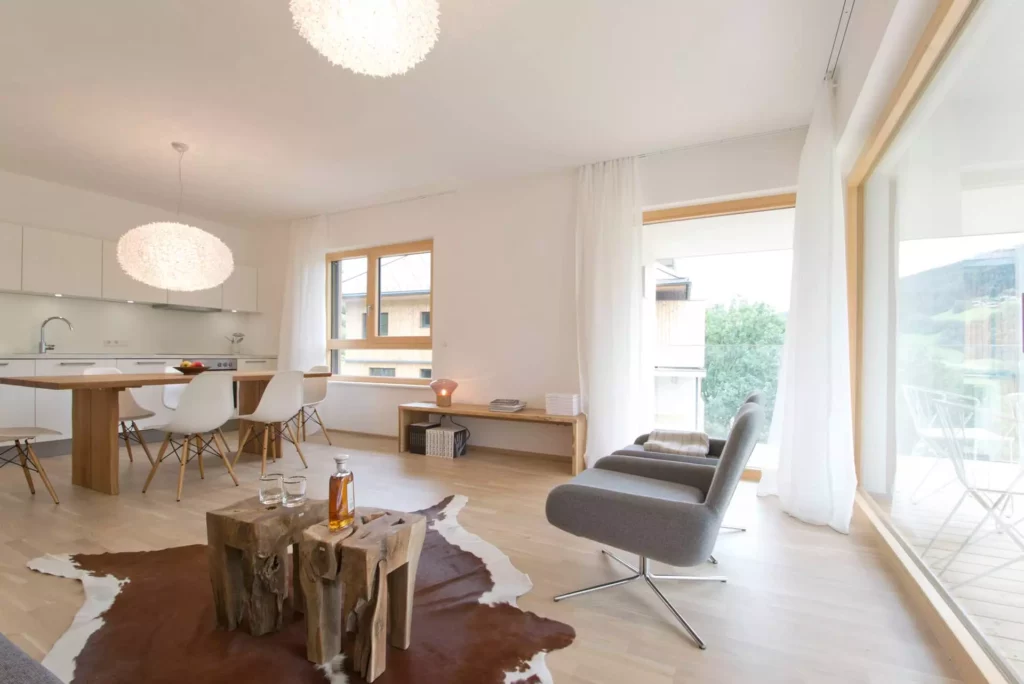 Helles Wohnzimmer und offene Küche mit maßgefertigtem Holztisch, Designermöbeln, Vitra Stühlen und Blick auf, Referenz