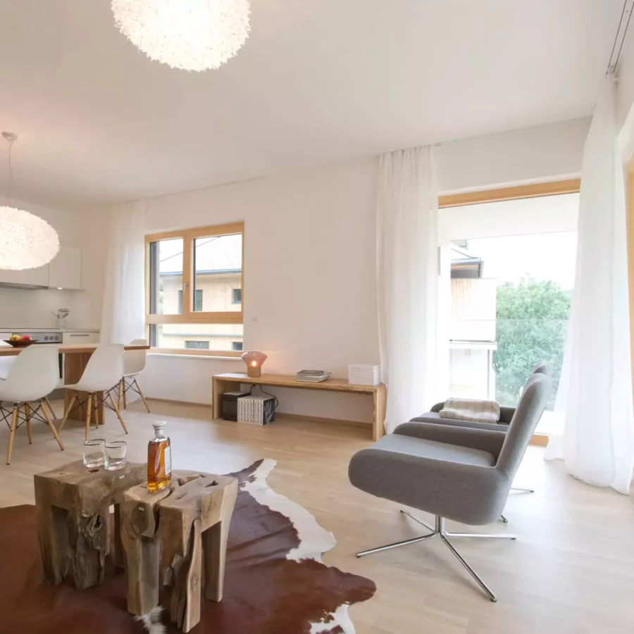 Helles Wohnzimmer und offene Küche mit maßgefertigtem Holztisch, Designermöbeln, Vitra Stühlen und Blick auf, Referenz