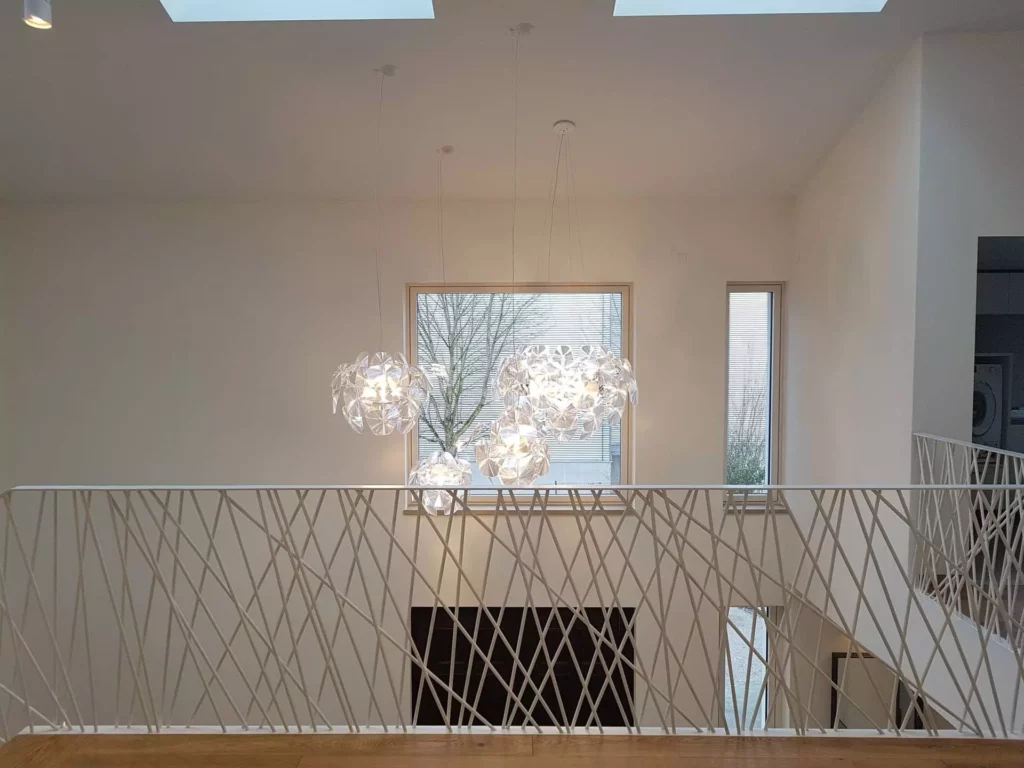 Moderner Treppenaufgang mit weißem, diagonal verlaufendem Geländer, großen Fenstern und drei designorientierten, Referenz