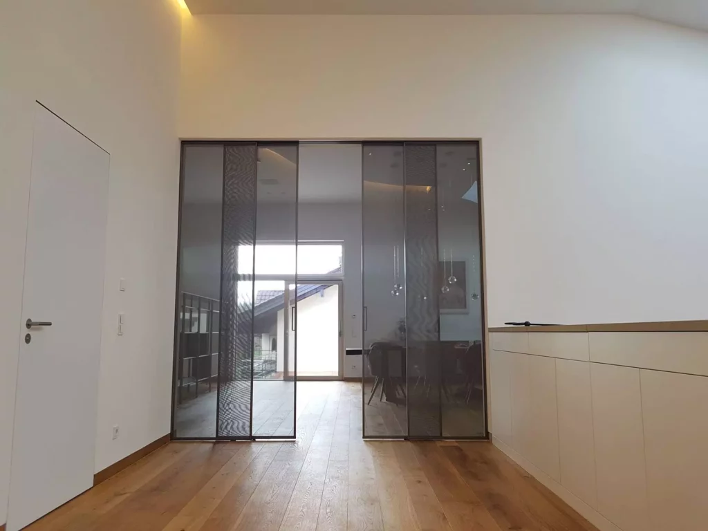 Moderner Wohnraum mit maßgefertigter Wandverkleidung, Glas-Schiebetüren von Rimadesio und Holzboden in Villa, Referenz