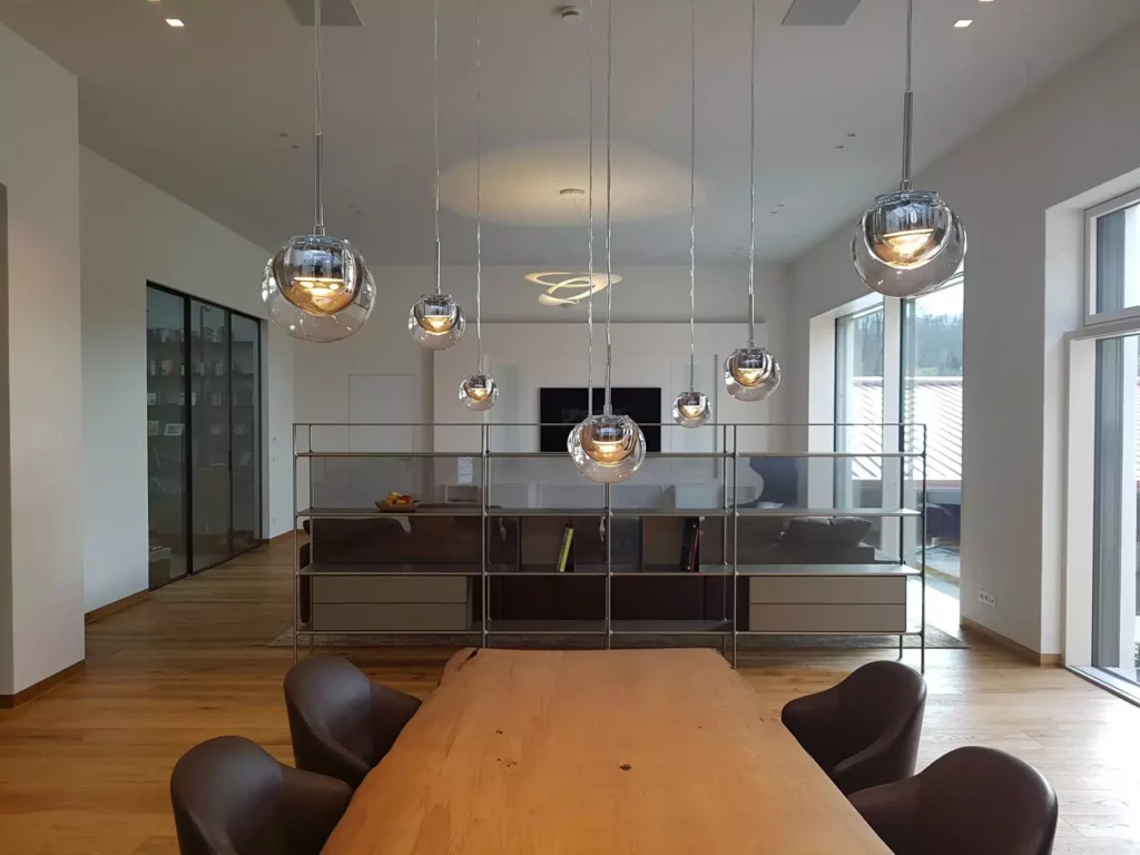 Moderner Wohnraum mit maßgefertigtem Holztisch, Designermöbeln von Minotti und Rimadesio, Pendelleuchten und großer, Referenz