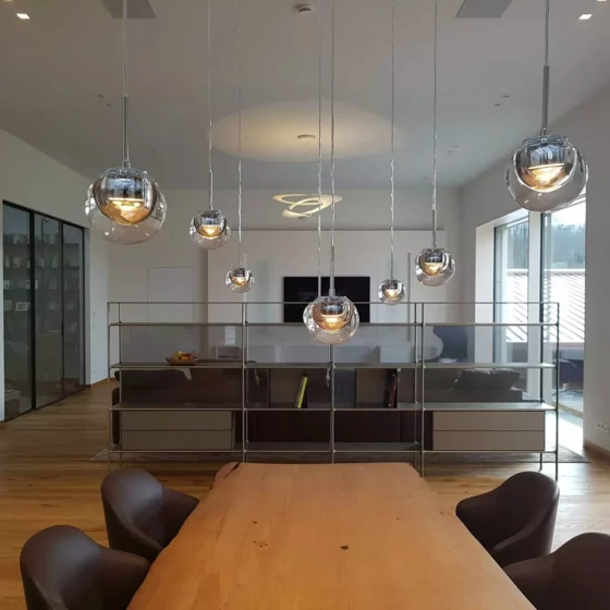 Moderner Wohnraum mit maßgefertigtem Holztisch, Designermöbeln von Minotti und Rimadesio, Pendelleuchten und großer, Referenz