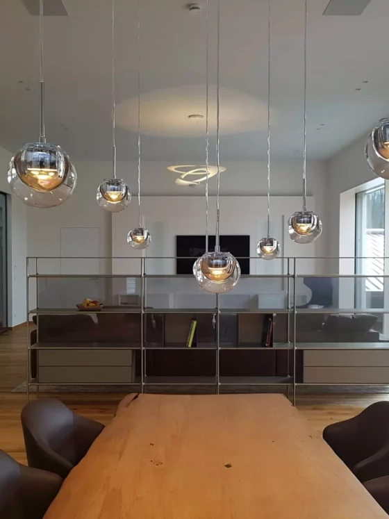 Moderner Wohnraum mit maßgefertigtem Holztisch, Designermöbeln von Minotti und Rimadesio, Pendelleuchten und großer, Referenz