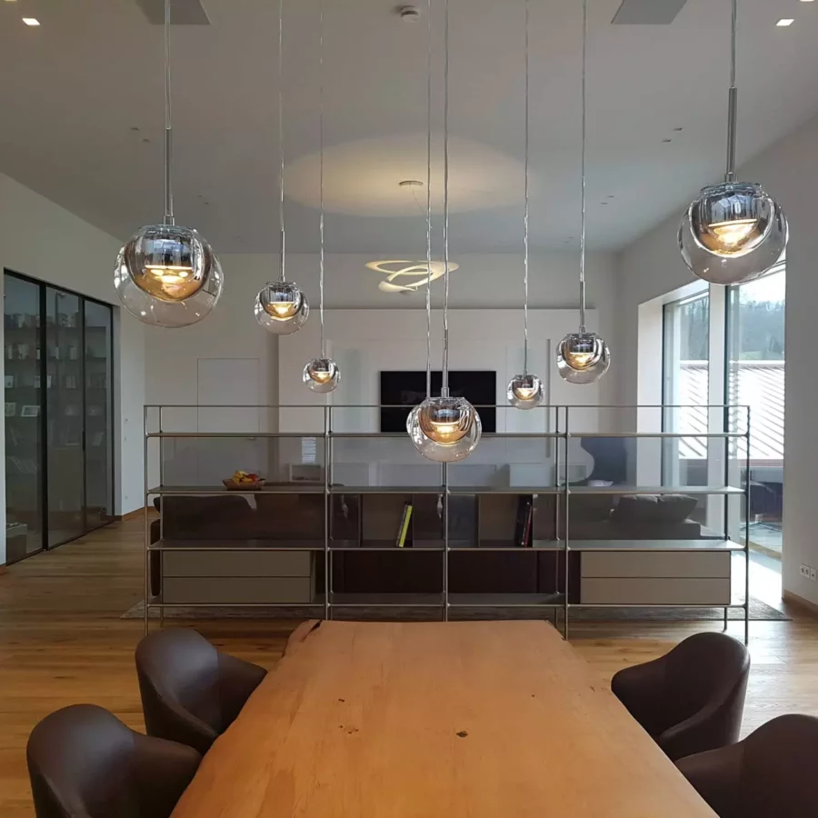 Moderner Wohnraum mit maßgefertigtem Holztisch, Designermöbeln von Minotti und Rimadesio, Pendelleuchten und großer, Referenz