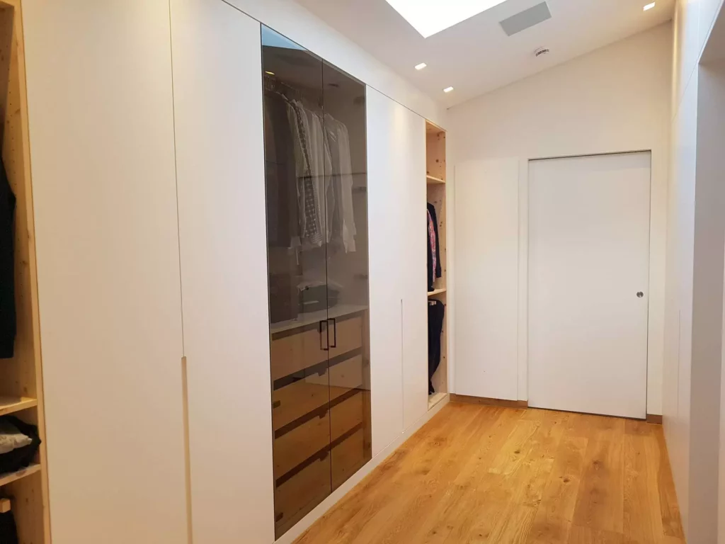 Moderner begehbarer Kleiderschrank mit maßgefertigten weißen Fronten und Glasfronten in einer Villa in Stuttgart, Referenz