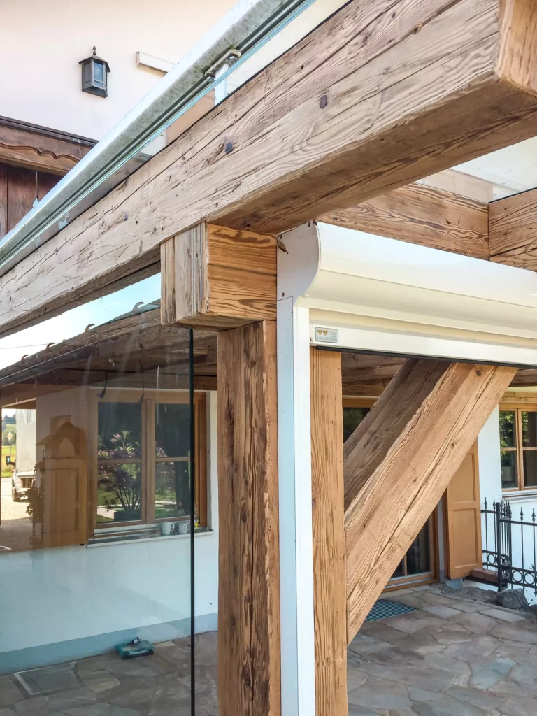 Detailaufnahme eines Altholzverbaus mit Glasgeländer und weißem Rollladenrahmen als Teil einer maßgefertigten, Altholzmöbel