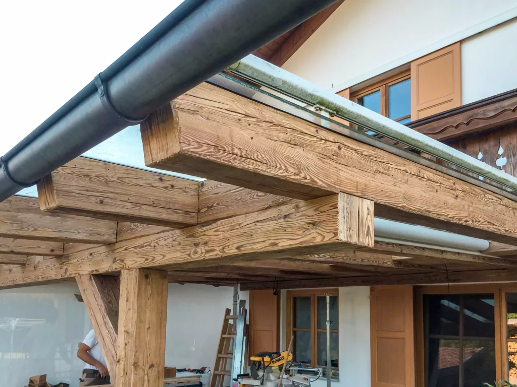Altholzverbau und Holzkonstruktion einer Terrasse mit Glasdach im Außenbereich eines Hauses, Tischlerei, Altholzmöbel