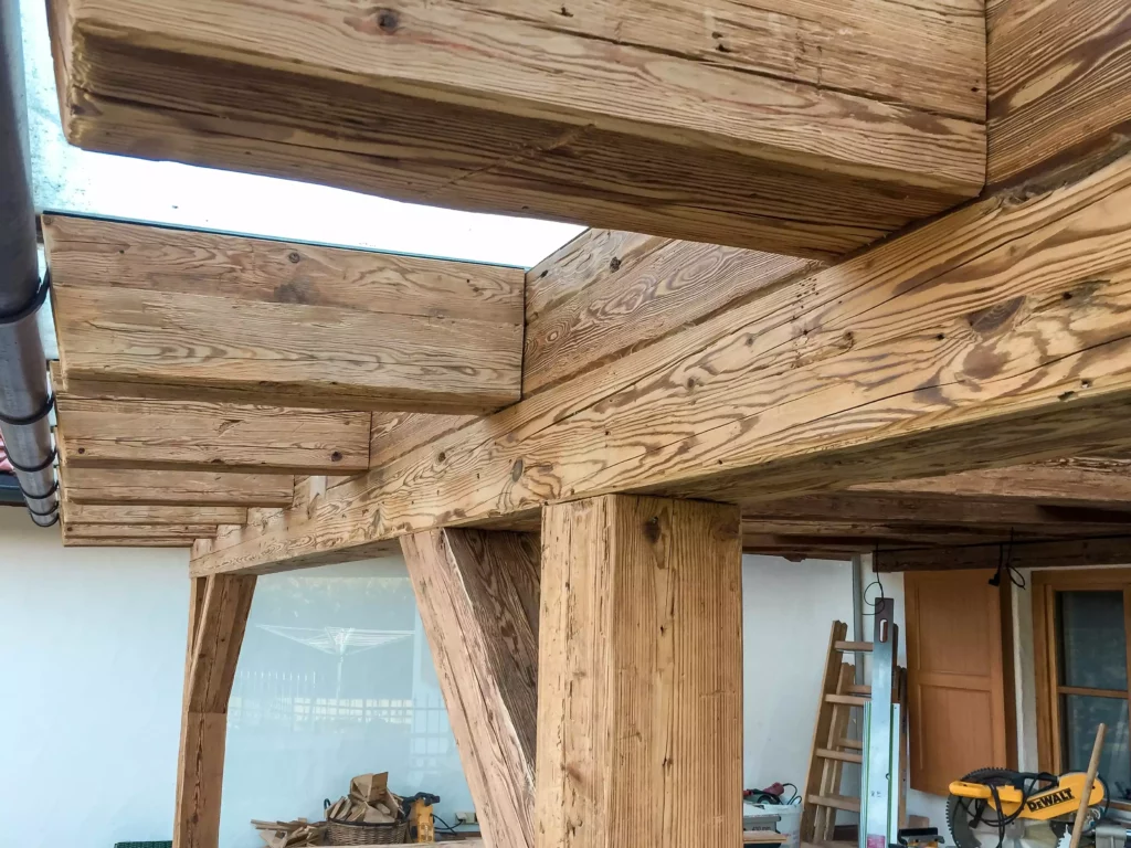 Altholzverbau mit sichtbaren Balken und Stützen aus massivem Holz in einer Tischlerei für Innenarchitektur, Altholzmöbel