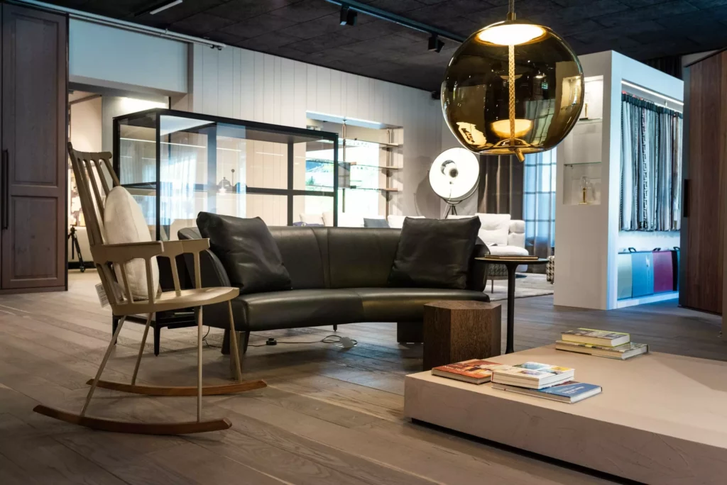 Moderner Showroom mit Designermöbeln wie Minotti Sofa, Schaukelstuhl, großer Hängelampe und Wohnraumplanungslösung