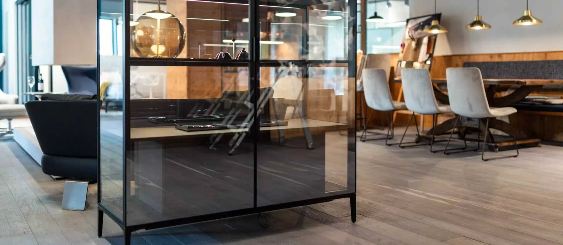 Moderner Showroom mit Glasvitrine, Designerstühlen und Holztisch in stilvoller Innenarchitektur und Möbelstudio-Atmosphäre
