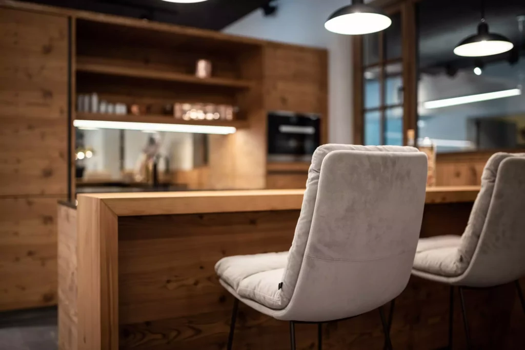 Moderner Showroom mit maßgefertigtem Holztresen und zwei gepolsterten Barhockern in elegantem Innenarchitektur-Design