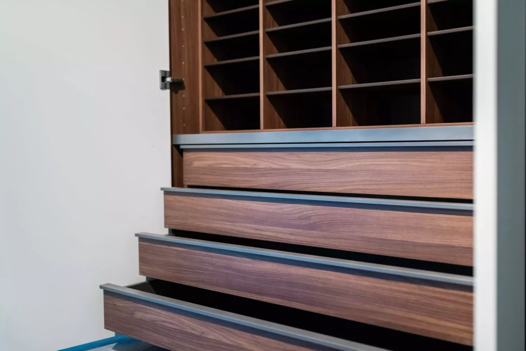 Offene Schubladen und Regalfächer aus dunklem Holz in einem modernen Möbelstudio Showroom mit maßgefertigter Innenarchitektur