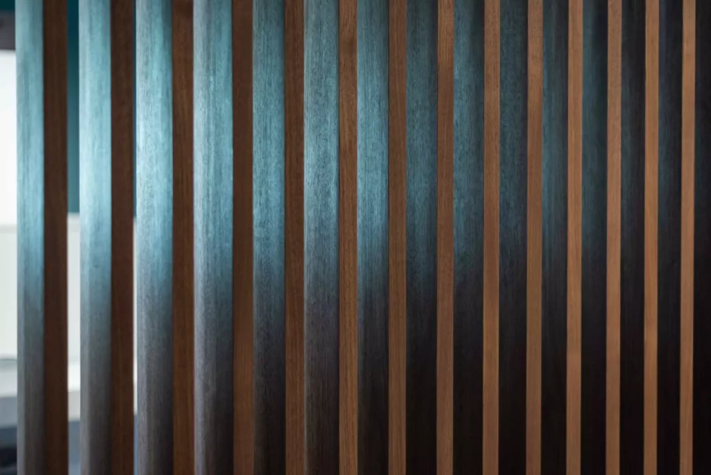 Holzlamellen als Raumteiler im modernen Showroom mit indirekter Beleuchtung, Innenarchitektur und Raumlösung