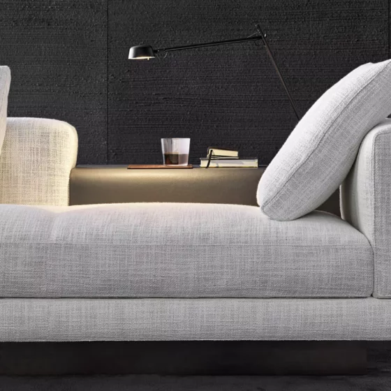 seitliche Ansicht eines weißen Minotti Sofas mit Kissen vor schwarzer Wand im Möbelstudio Altenmarkt Salzburg