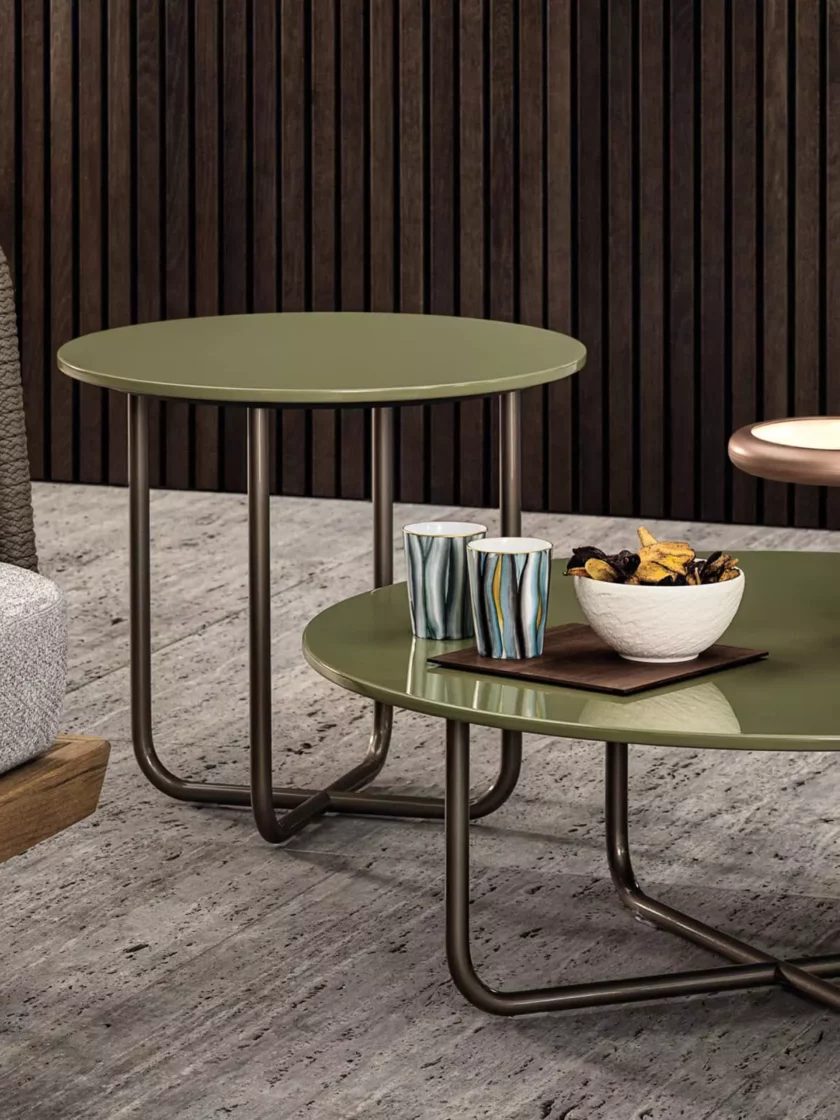 Zwei grüne Minotti Beistelltische mit Metallgestell neben grauem Sofa mit grünem Kissen in modernem Wohnzimmer mit