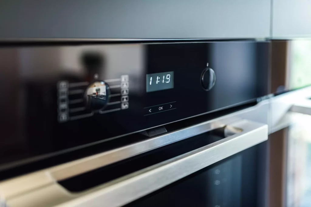 Nahaufnahme eines modernen Poliform Alea Phoenix Backofens mit digitaler Anzeige und Edelstahlgriff in einer maßgefertigten