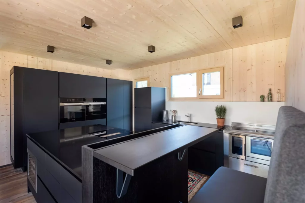 Moderne Poliform Alea Küche in Salzburg mit schwarzer Front, Miele Geräten, Holzdecke und integrierter Sitzbank im