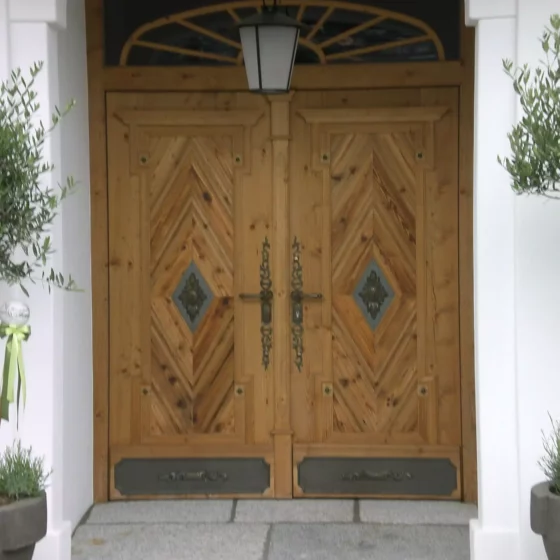 Eingang mit doppelflügeliger Holztür aus der Tischlerei Weitgasser in Altenmarkt, dekorative Beschläge und Laterne, umrahmt