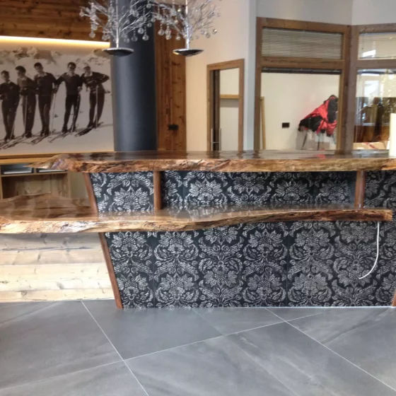 Theke mit massiver Holzplatte und floral gemustertem Frontpaneel in modernem Innenraum mit Holz- und, Weitgasser