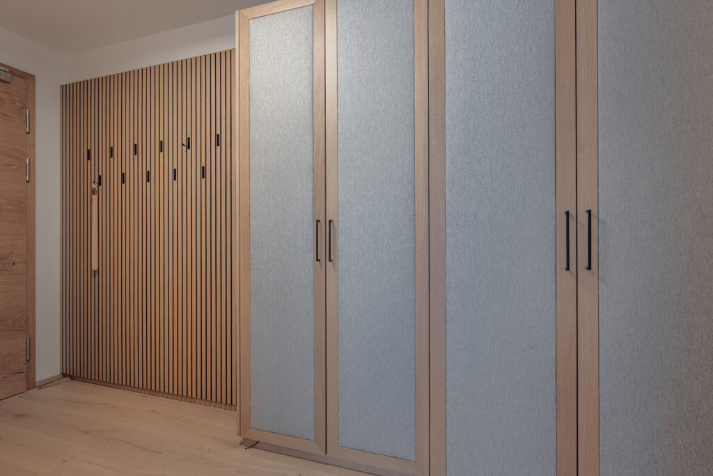 Moderner Eingangsbereich mit maßgefertigter Holzpaneelwand mit Haken und großem Schrank mit grauen Stofffronten, Einrichtung