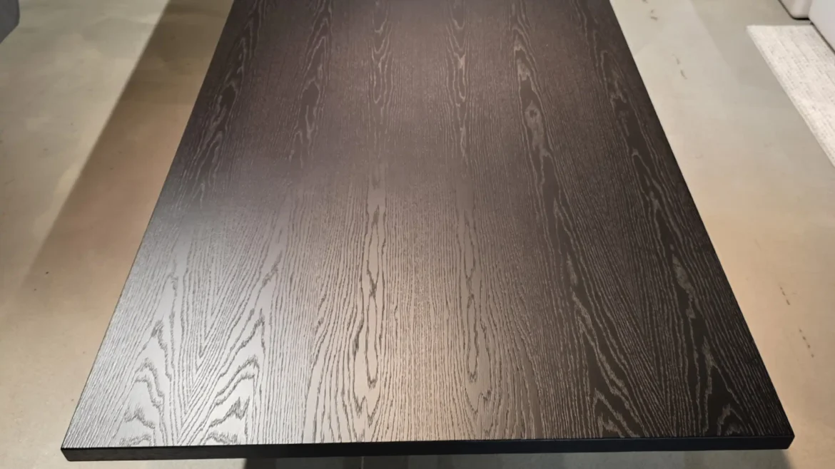 Schwarzer Minotti Linha Tisch mit Holzmaserung im modernen Showroom für Innenarchitektur und Designermöbel