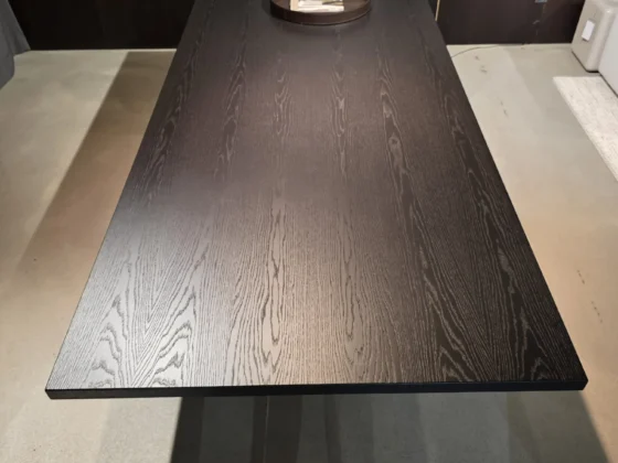 Schwarzer Minotti Linha Tisch mit Holzmaserung im modernen Showroom für Innenarchitektur und Designermöbel