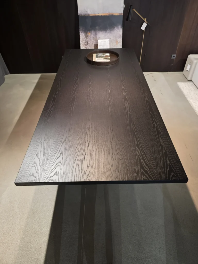 Schwarzer Minotti Linha Tisch mit Holzmaserung im modernen Showroom für Innenarchitektur und Designermöbel