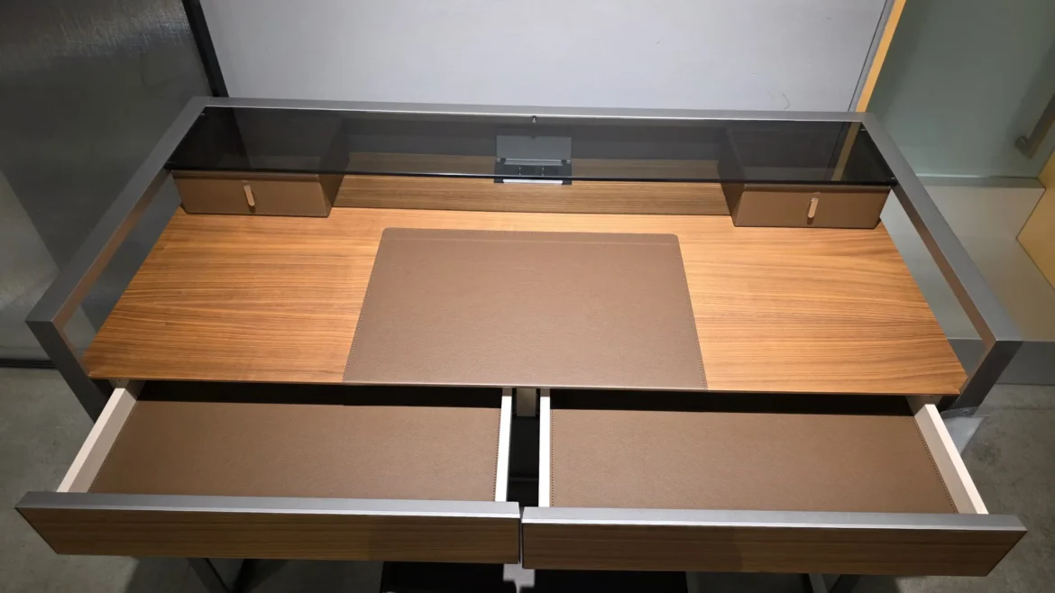 Moderner Rimadesio Rialto Tisch mit Holzplatte, braunen Lederauflagen und Metallrahmen im Showroom für Innenarchitektur und