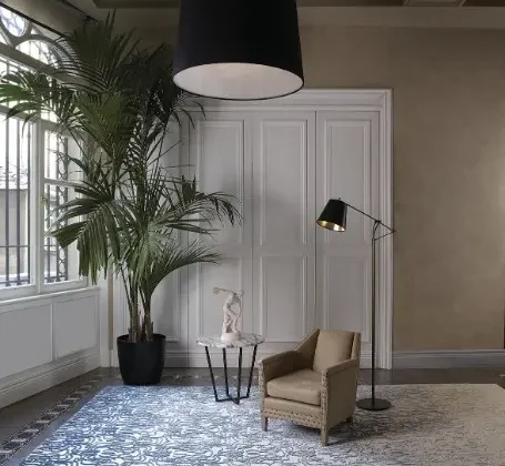 Moderner Wohnraum mit Stepevi Teppich Fade, Ledersessel, Stehlampe, Beistelltisch und großer Zimmerpflanze im Showroomstil