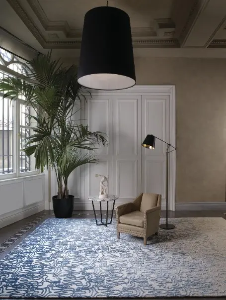 Moderner Wohnraum mit Stepevi Teppich Fade, Ledersessel, Stehlampe, Beistelltisch und großer Zimmerpflanze im Showroomstil