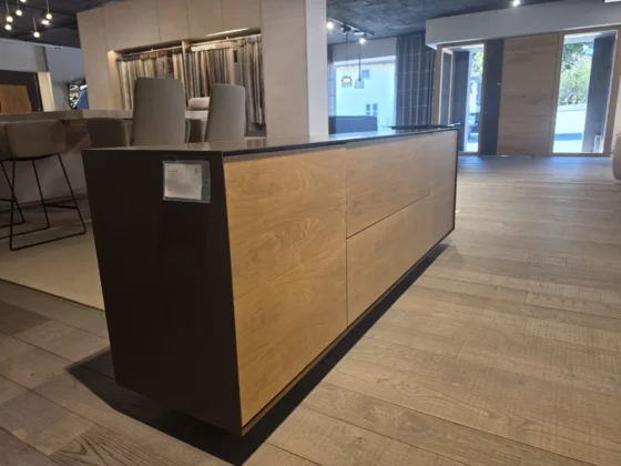 Moderner Holz- und Metall-Sideboard im Möbelstudio mit Stühlen und Stoffmustern im Hintergrund