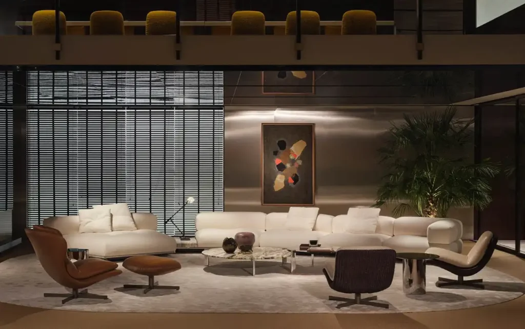 Modernes Wohnzimmer mit weißem Ecksofa, braunen Sesseln, Marmor-Couchtisch, abstraktem Wandbild und großer Zimmerpflanze im